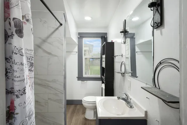 a bathroom with a sink a toilet and shower