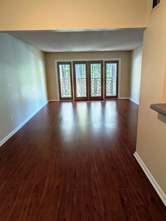3650 Ashford Dunwoody Road Northeast, Unit 918 Atlanta, GA 30319 - Photo 3 of 17 a view of an empty room with wooden floor and a window