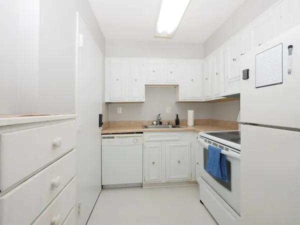 a kitchen with cabinets stainless steel appliances and sink