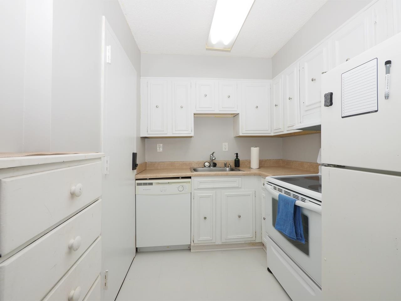 232 South Highland Street, Unit 505 Memphis, TN 38111 - Photo 4 of 7 Kitchen featuring white appliances, light countertops, and white cabinetry