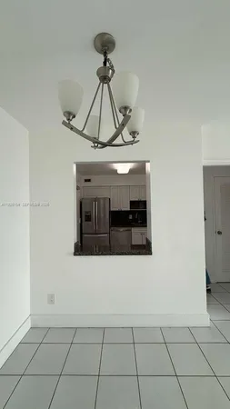 a living room with stainless steel appliances kitchen island granite countertop a rug a stove and white cabinets