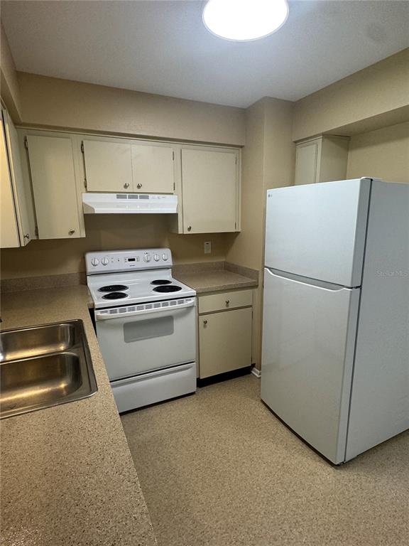 5222 Bogdonoff Drive, Unit A Seffner, FL 33584 - Photo 6 of 16 a kitchen with a refrigerator sink stove and cabinets