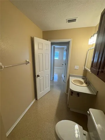 a bathroom with a sink mirror vanity and toilet