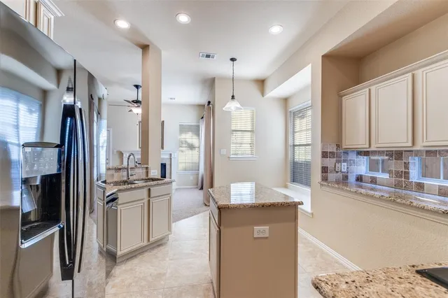 a kitchen with kitchen island a counter top space appliances and a ceiling fan