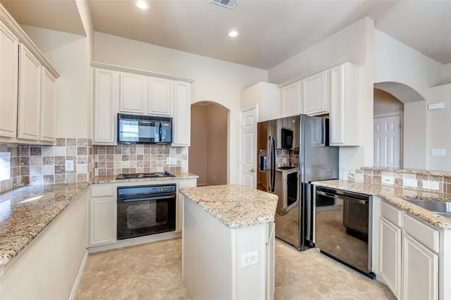 a kitchen with stainless steel appliances granite countertop a stove top oven a sink and dishwasher