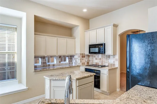 a kitchen with stainless steel appliances granite countertop a stove and a refrigerator