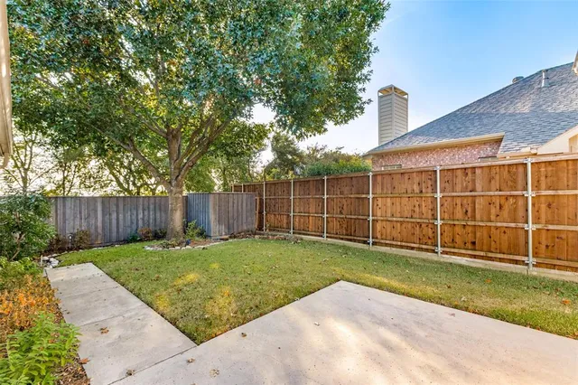 a view of a backyard with a wooden fence