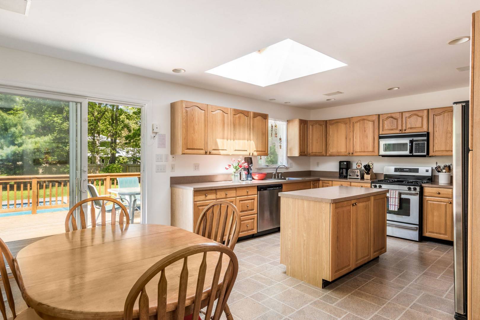 41 Sandra Road East Hampton, NY 11937 - Photo 5 of 16 a kitchen with stainless steel appliances granite countertop a stove top oven a sink a dining table and chairs