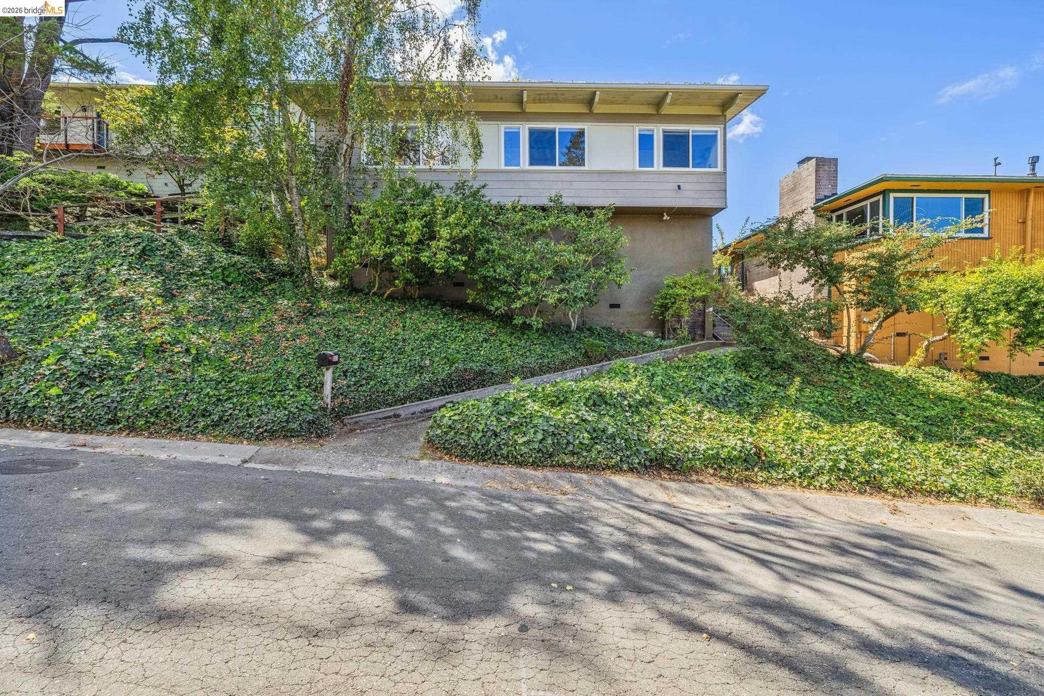 1024 Overlook Road Berkeley, CA 94708 - Photo 10 of 41 Multi-level exterior with a flat roofline, upper-level windows, and a lower-level stucco finish