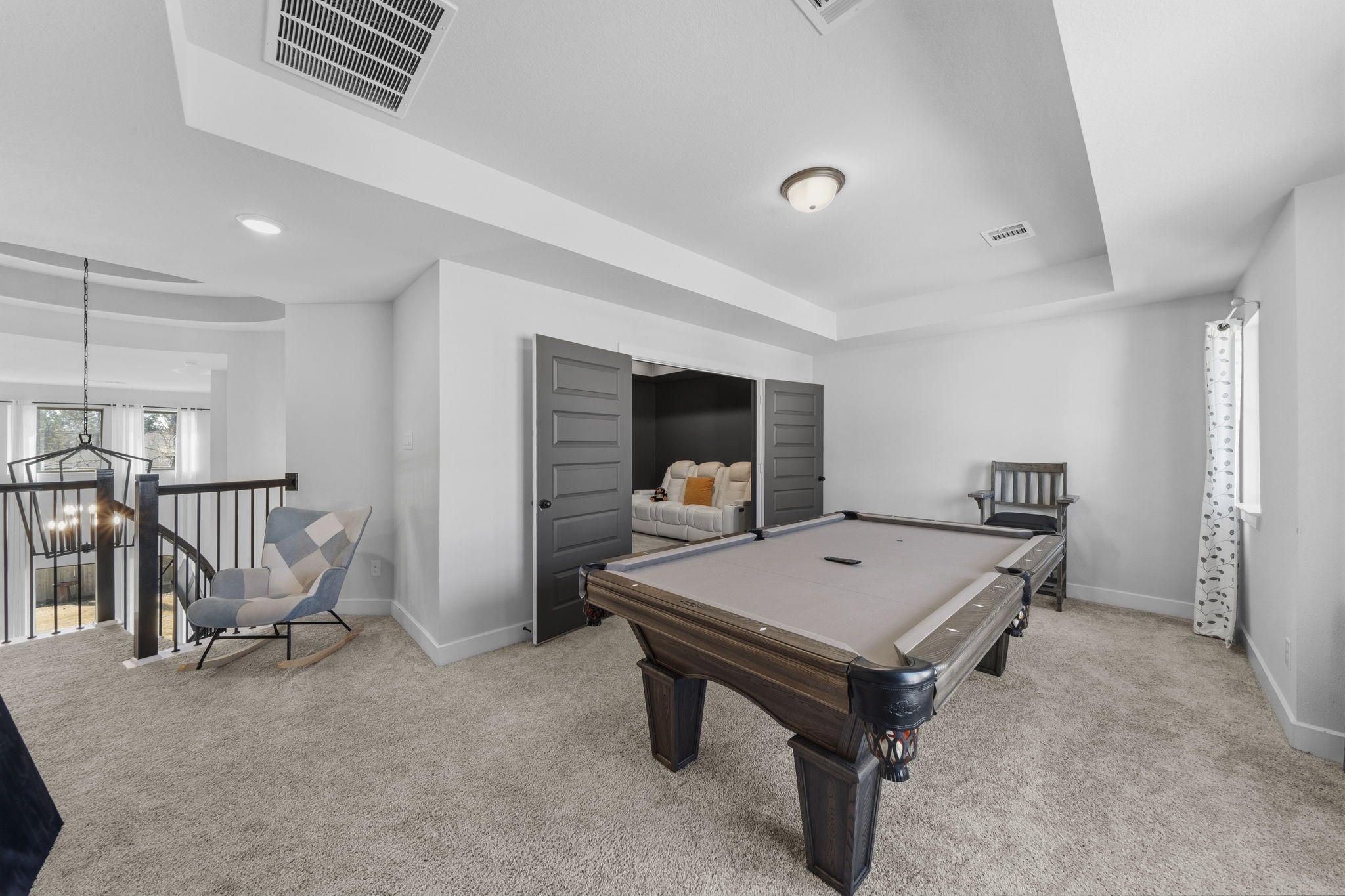 511 Carina Gaze Drive Conroe, TX 77318 - Photo 22 of 45 This spacious loft area/game room perfect for a pool table and cozy seating. Adjacent is a small media room, perfect for entertainment. Natural light streams in through windows, enhancing the inviting atmosphere.