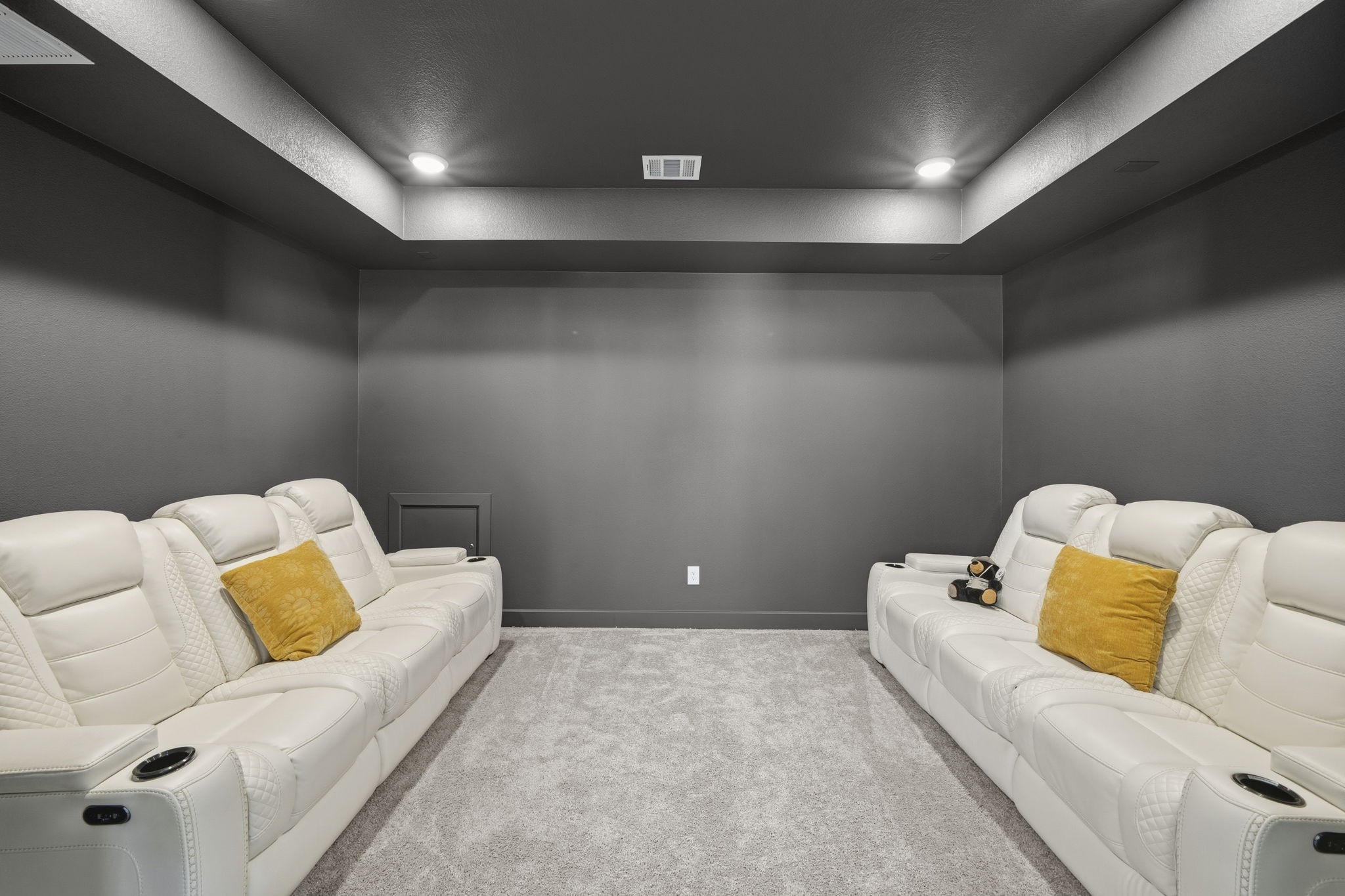 511 Carina Gaze Drive Conroe, TX 77318 - Photo 25 of 45 This photo showcases a modern home theater room. The room features soft, recessed lighting and dark walls for an immersive viewing experience.