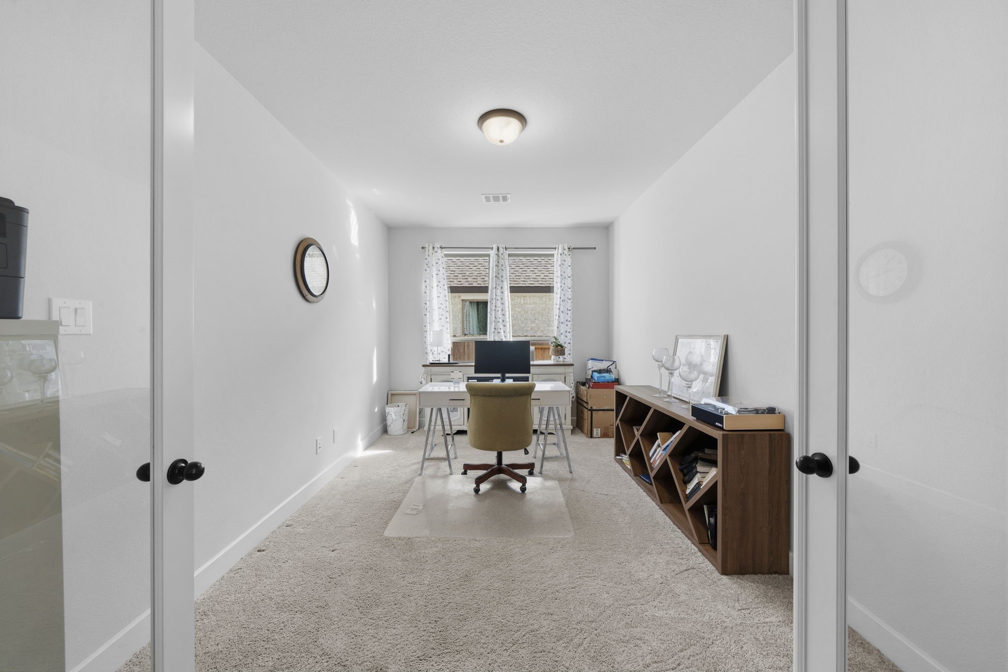 511 Carina Gaze Drive Conroe, TX 77318 - Photo 8 of 45 This photo showcases a bright, narrow office space with carpeted flooring.