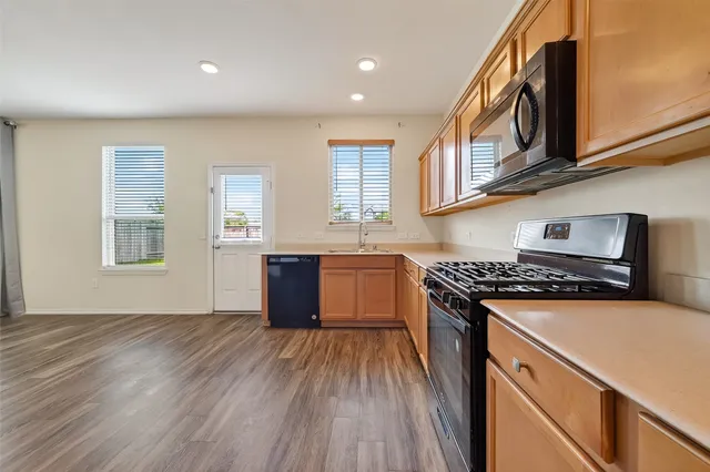 a kitchen with stainless steel appliances granite countertop a stove a sink and a refrigerator