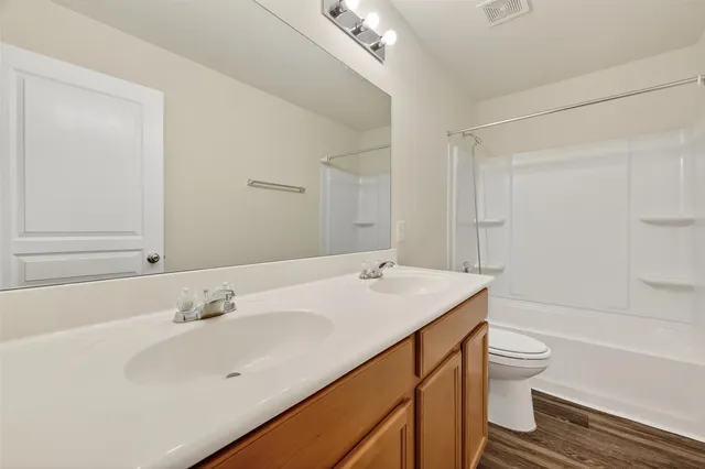a bathroom with a sink a toilet and shower