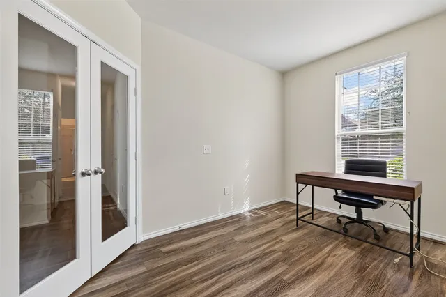 a view of a workspace with wooden floor and a window