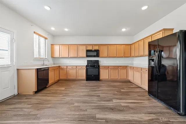 a kitchen with stainless steel appliances kitchen island granite countertop a refrigerator and a sink