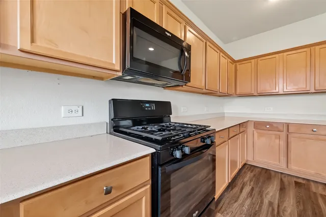 a kitchen with stainless steel appliances granite countertop a stove and a microwave