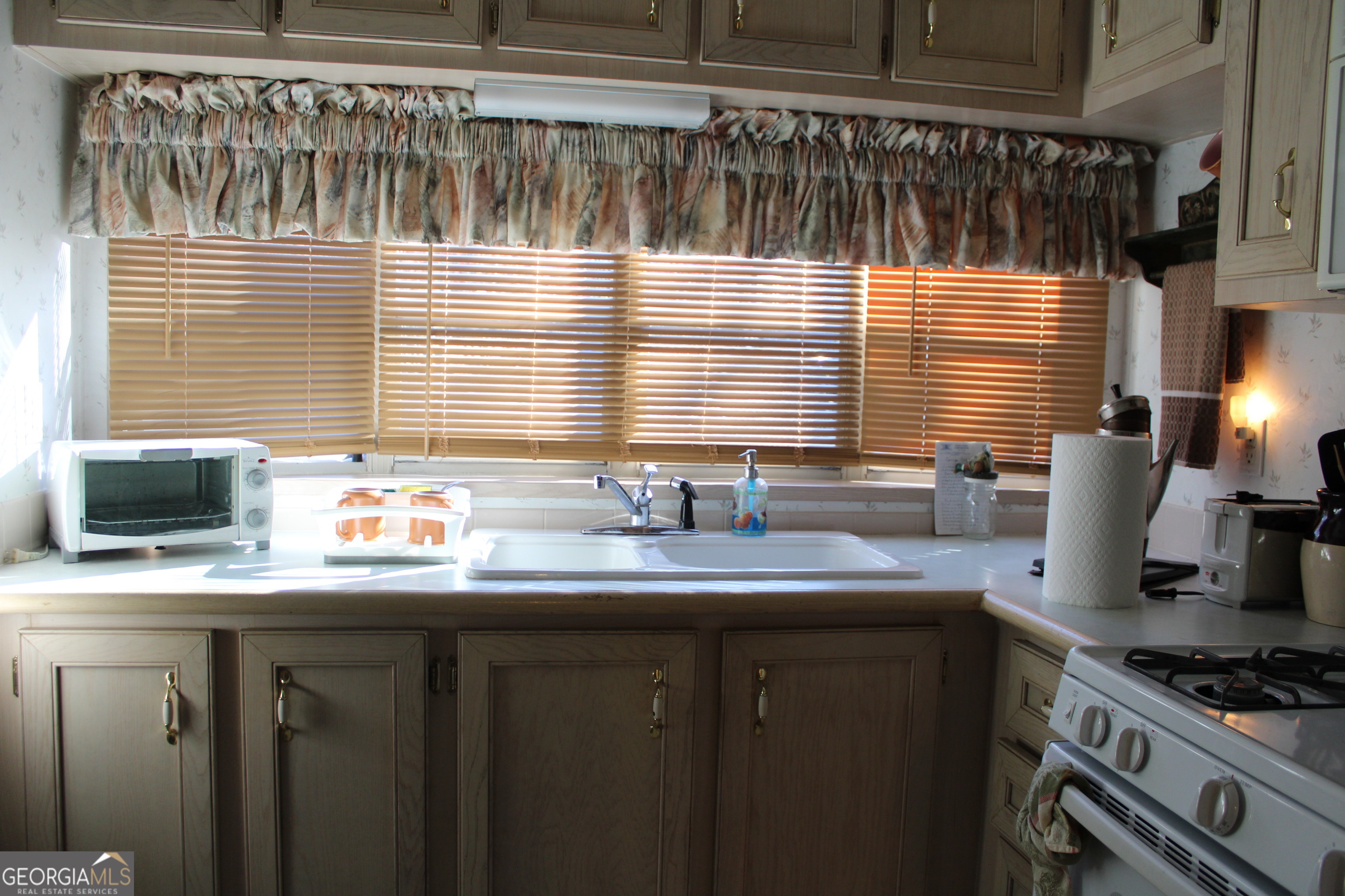 79 Maple Wood Lane Cleveland, GA 30528 - Photo 10 of 18 a kitchen with stainless steel appliances a sink a stove and a window