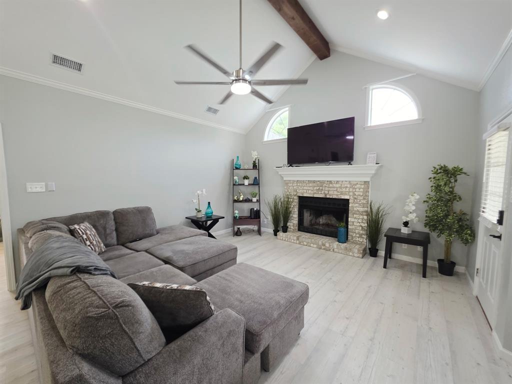 520 Red River Road Belton, TX 76513 - Photo 24 of 36 Spacious living area featuring a vaulted ceiling with a prominent wood beam, arched windows, and light wood-finish flooring