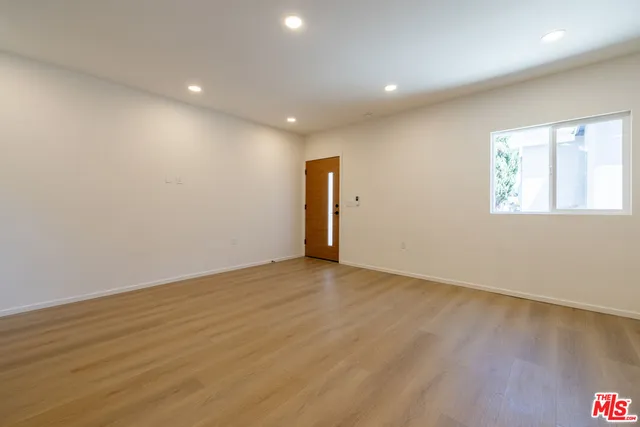 a view of empty room with wooden floor and fireplace
