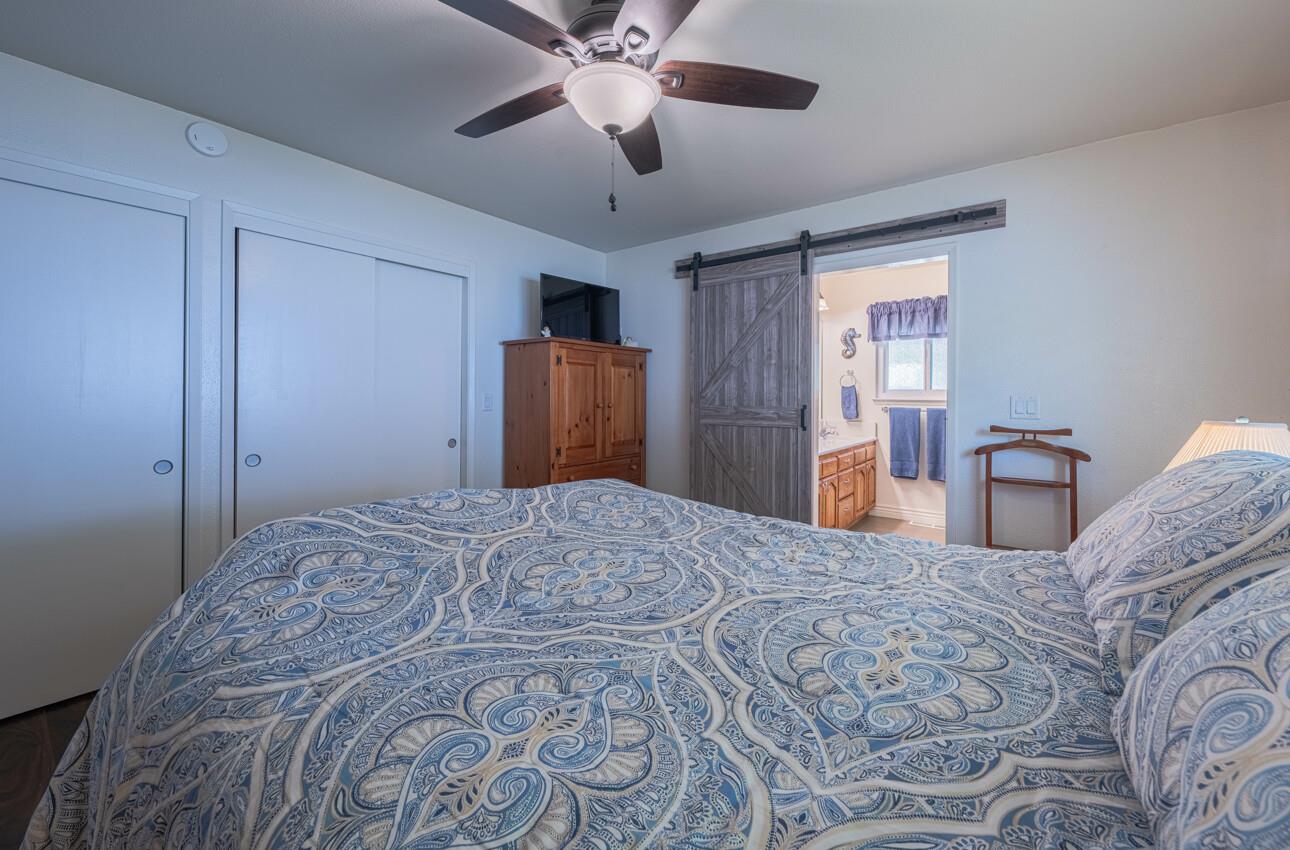 18101 Berta Canyon Road Salinas, CA 93907 - Photo 15 of 32 a bedroom with a bed and a chandelier