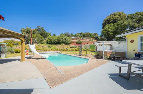 a swimming pool with outdoor seating and yard