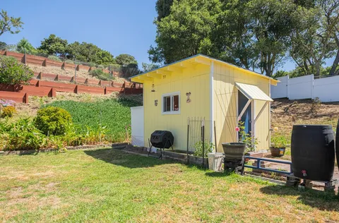 a view of backyard with a barn in the background