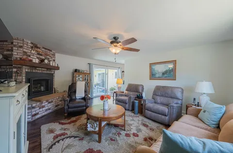a living room with furniture a fireplace and a chandelier