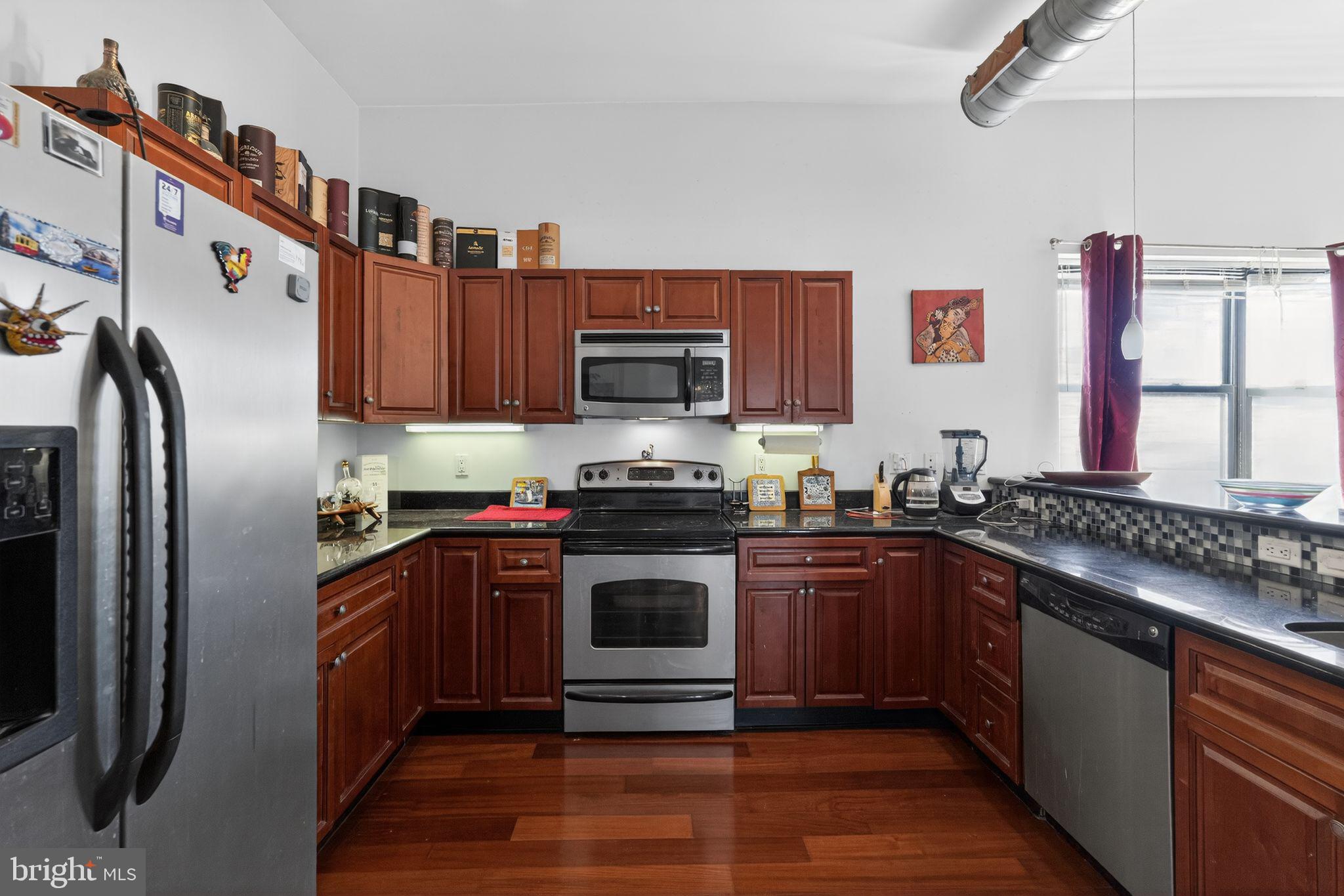 926 North 3rd Street, Unit 4D Philadelphia, PA 19123 - Photo 7 of 15 a kitchen with stainless steel appliances granite countertop a stove a sink and a refrigerator