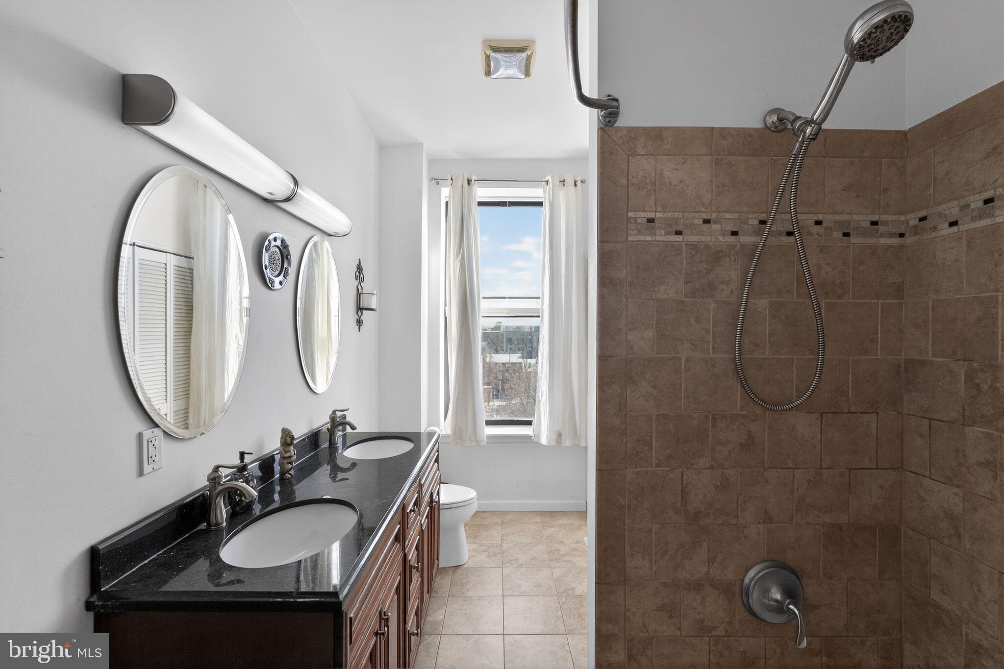 926 North 3rd Street, Unit 4D Philadelphia, PA 19123 - Photo 8 of 15 a bathroom with a sink a mirror a vanity and a shower