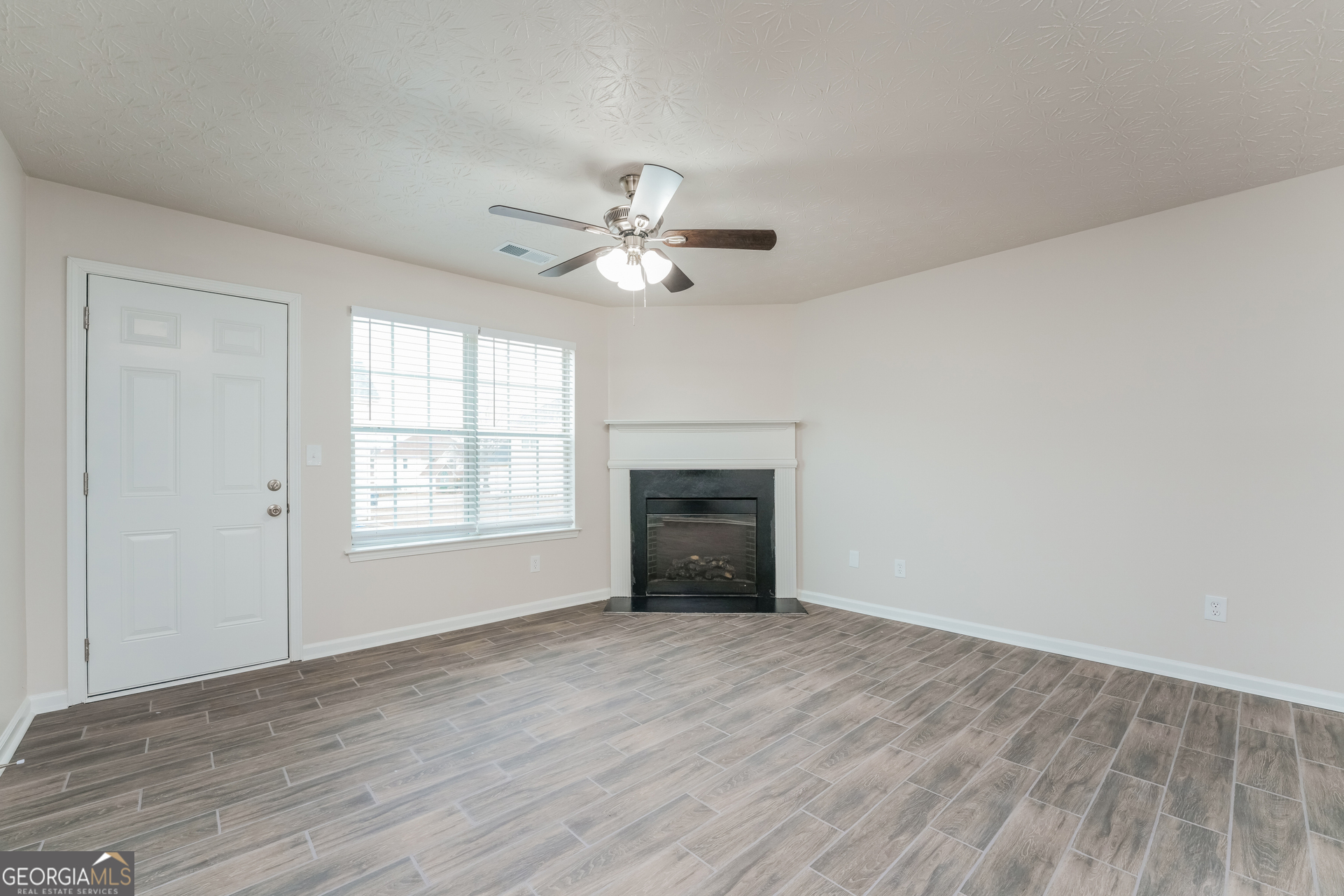 15 Emerson Trail Covington, GA 30016 - Photo 7 of 17 a view of an empty room with a window and a kitchen