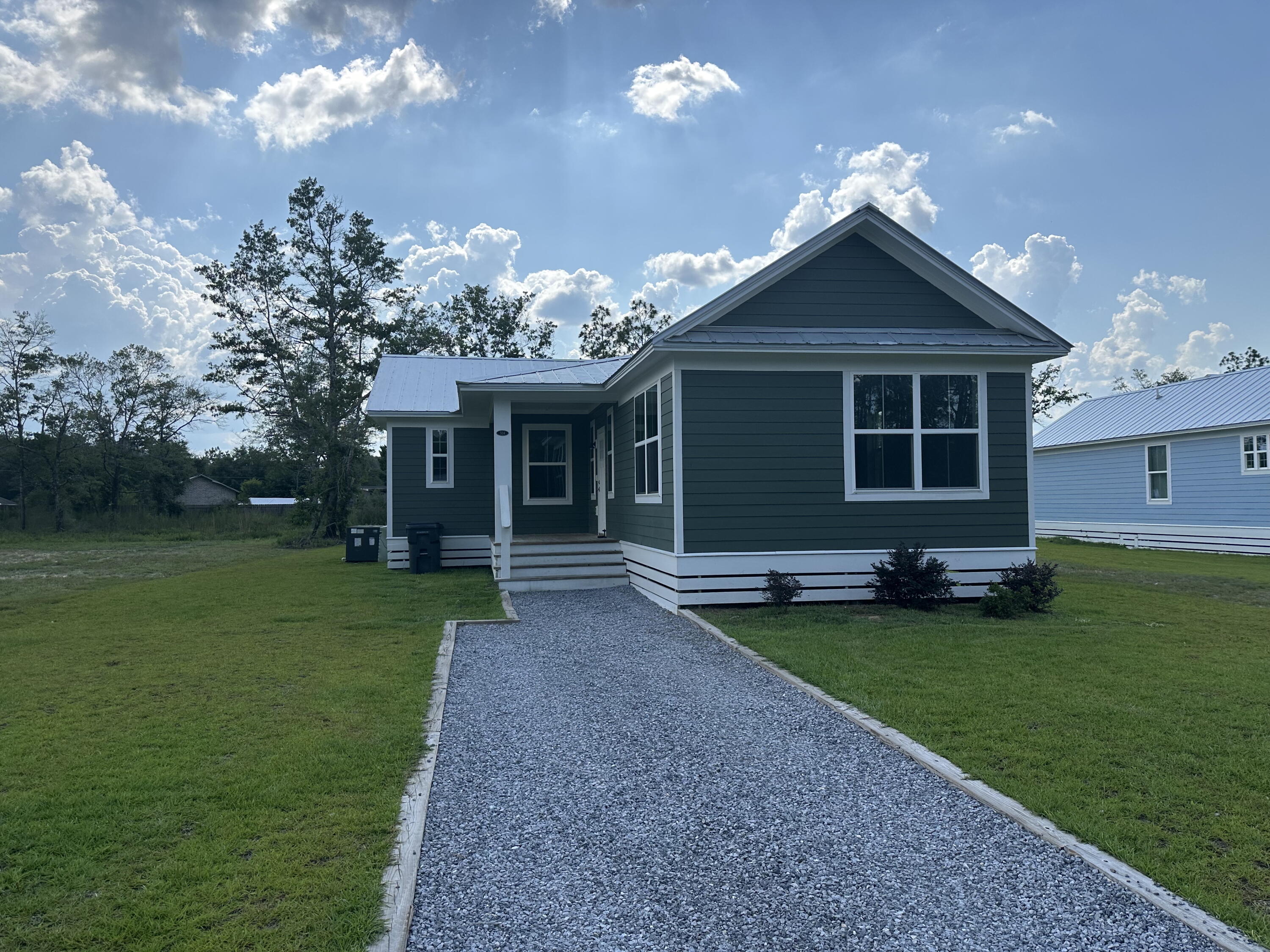 a front view of a house with a garden