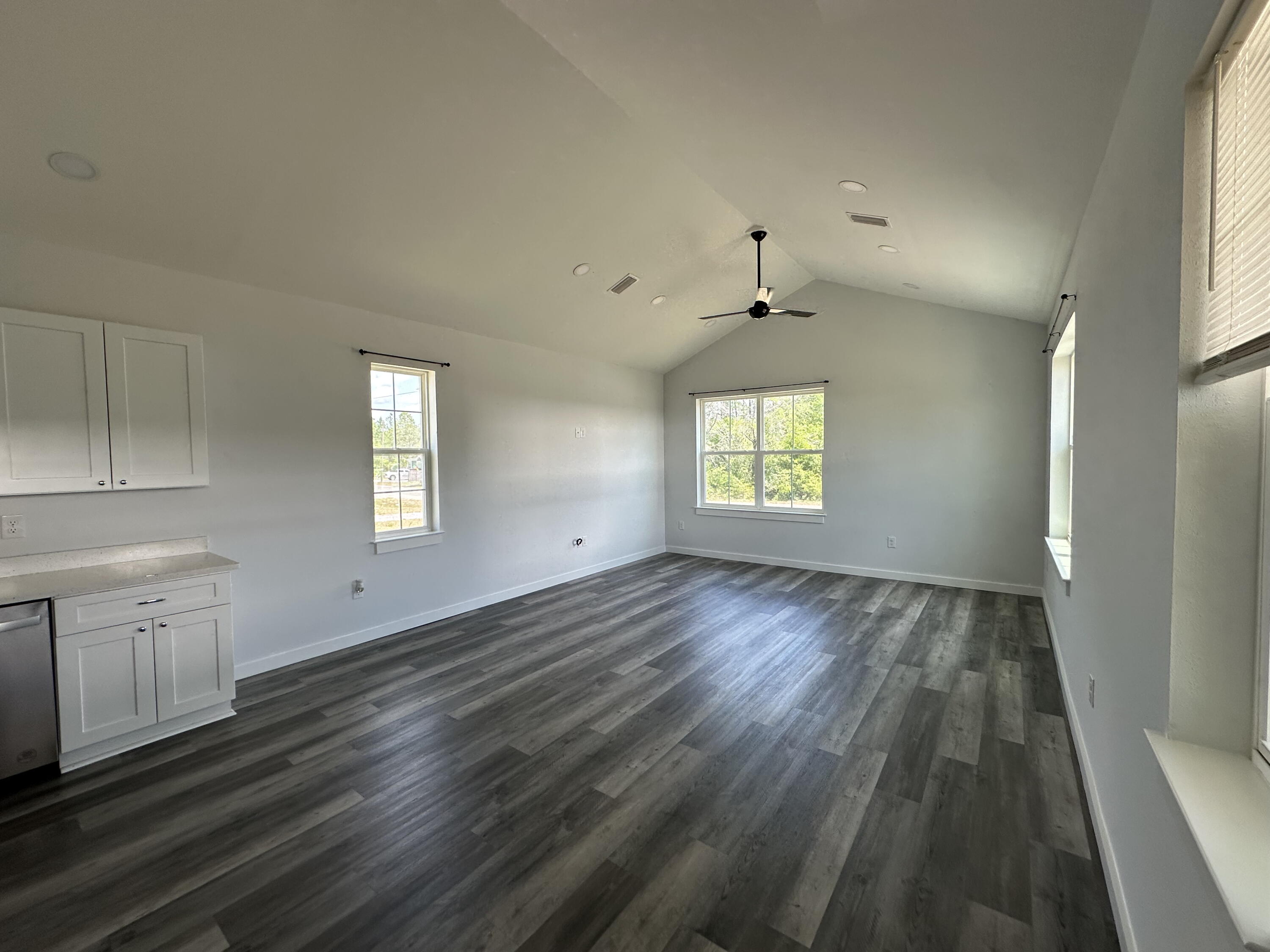 534 North Raphael Road DeFuniak Springs, FL 32433 - Photo 6 of 20 an empty room with wooden floor and windows