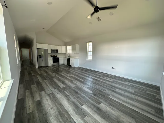 a view of a bedroom with wooden floor