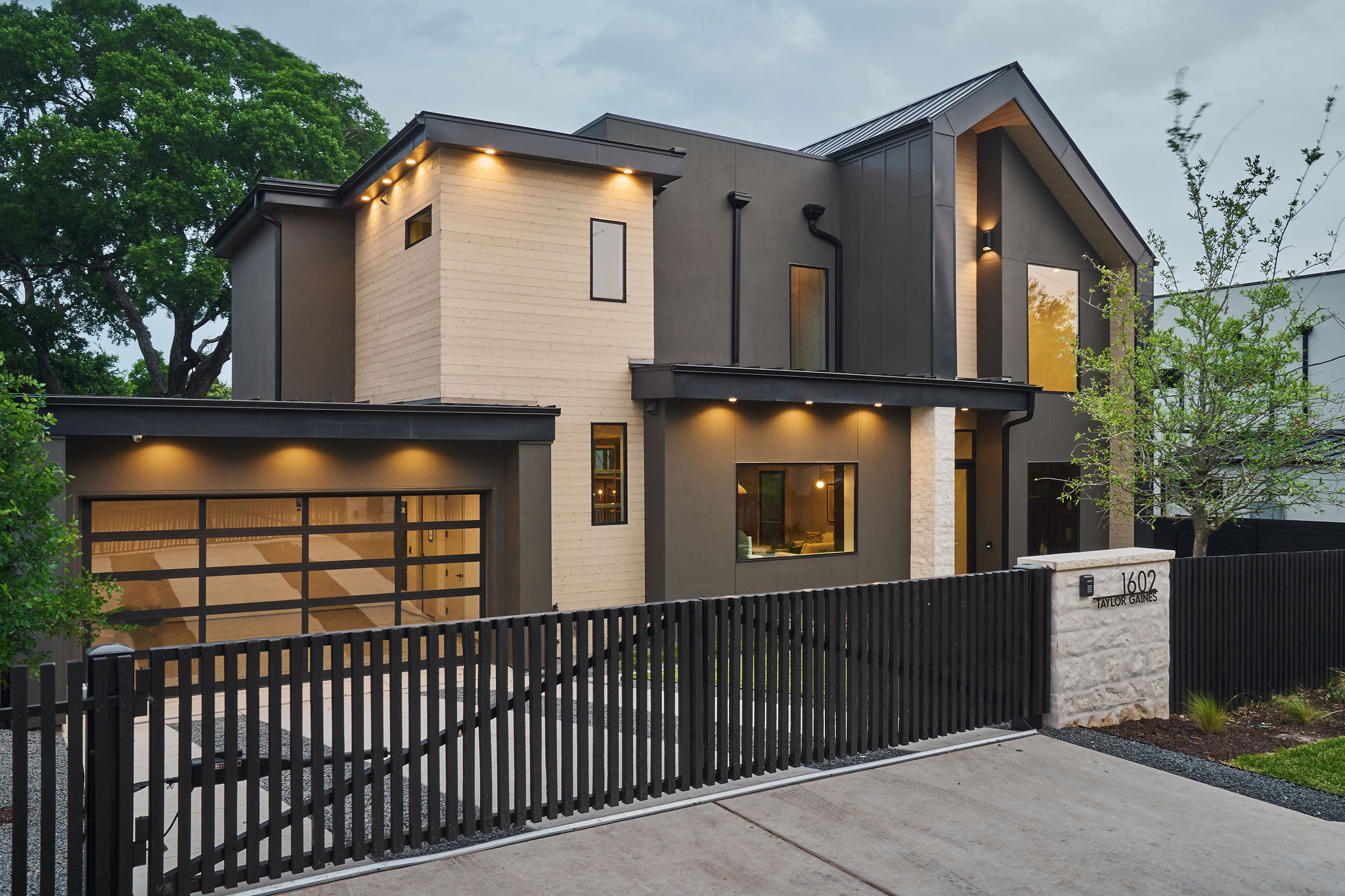 1602 Taylor Gaines Street Austin, TX 78741 - Photo 2 of 40 Modern home featuring a fenced front yard, a gate, a garage, and driveway