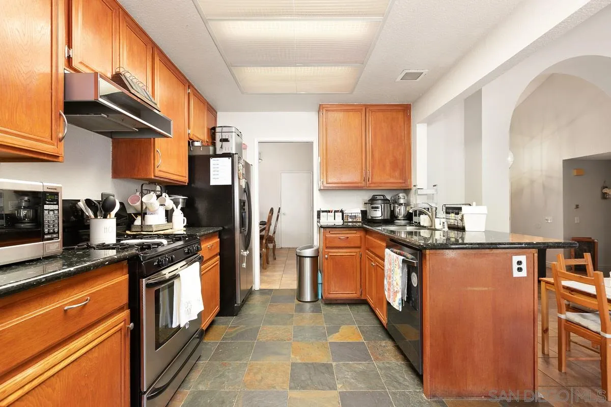 10551 Cadwell Road Santee, CA 92071 - Photo 15 of 32 a kitchen with stainless steel appliances granite countertop a stove top oven a sink dishwasher a refrigerator and cabinets with wooden floor