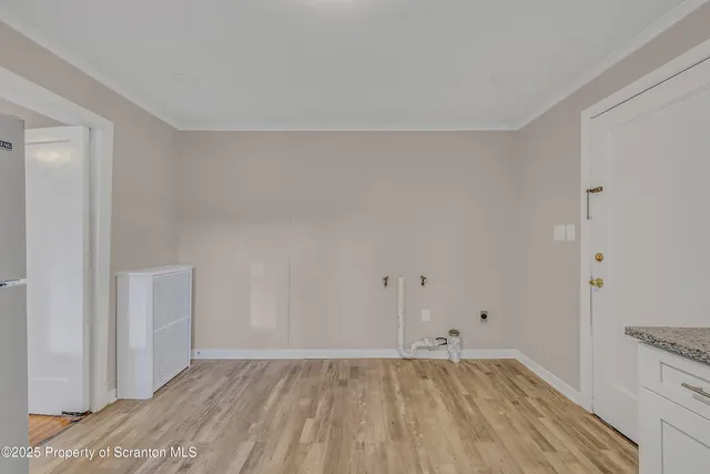 a view of an empty room with wooden floor and closet