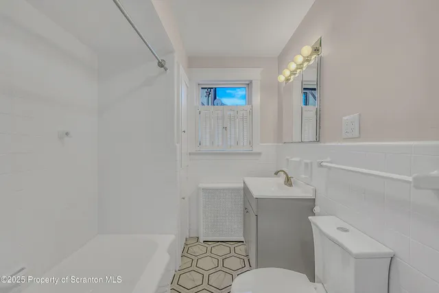 a bathroom with a sink toilet vanity and mirror