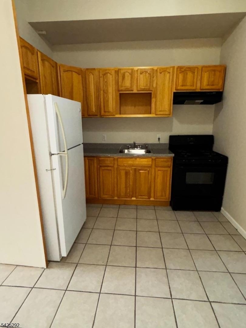 40 Broadway, Unit 5B Paterson, NJ 07505 - Photo 4 of 7 a kitchen with stainless steel appliances granite countertop a refrigerator a stove top oven a sink and dishwasher