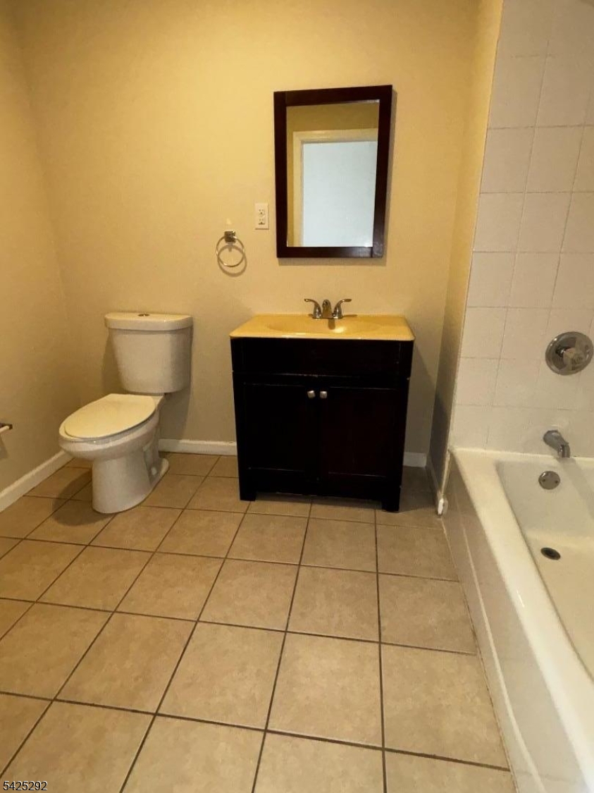 40 Broadway, Unit 5B Paterson, NJ 07505 - Photo 7 of 7 a bathroom with a sink a toilet and mirror