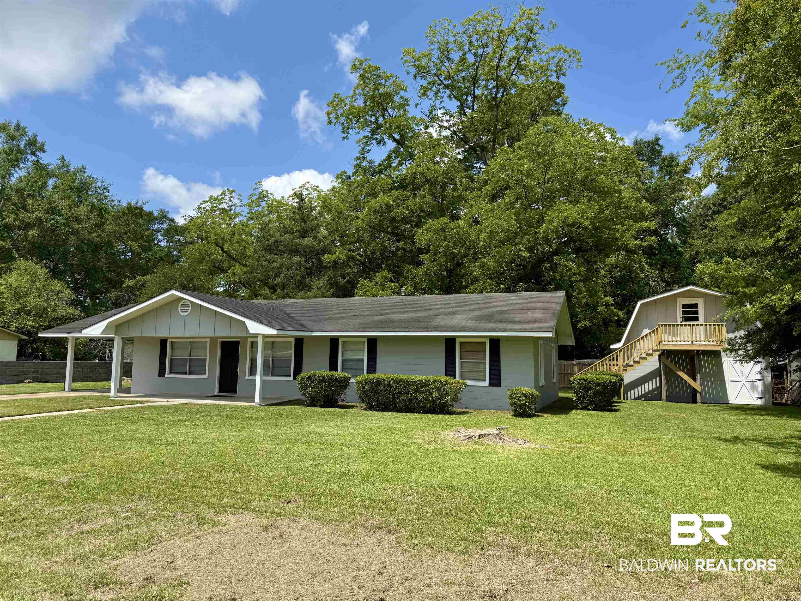 103 Kimberly Street Brewton, AL 36426 - Photo 2 of 18 View of front of home featuring stairway, a front lawn, and a shingled roof