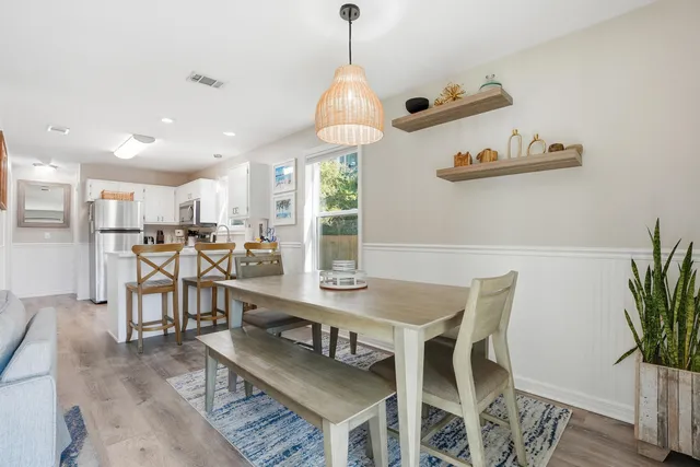 a dining room with furniture a chandelier and wooden floor