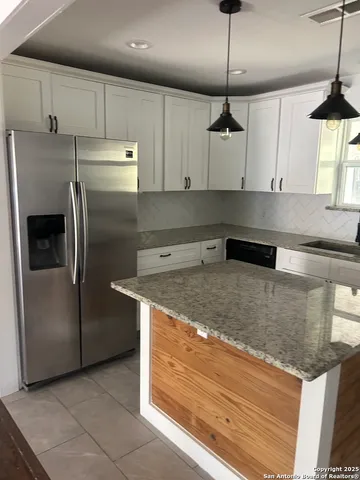 a kitchen with stainless steel appliances granite countertop a sink a refrigerator and a granite counter tops