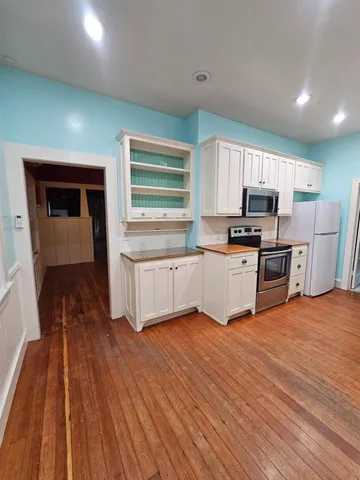 a kitchen with granite countertop a stove top oven and cabinets