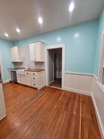 a view of kitchen with cabinets and wooden floor
