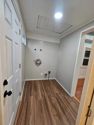 a view of a room with wooden floor and brick walls