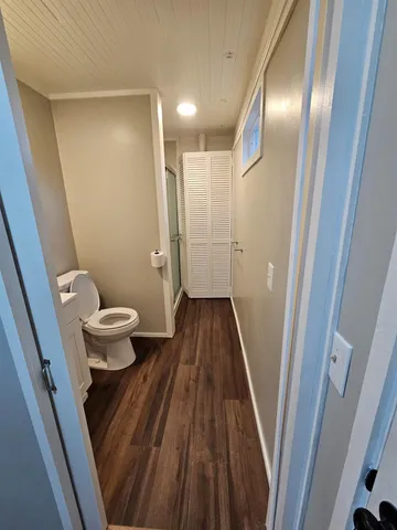 a bathroom with a granite countertop toilet sink and mirror
