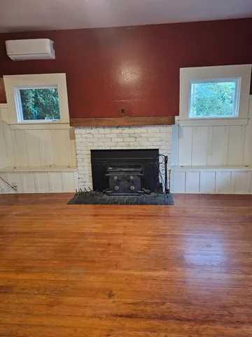 a view of empty room with wooden floor and fireplace