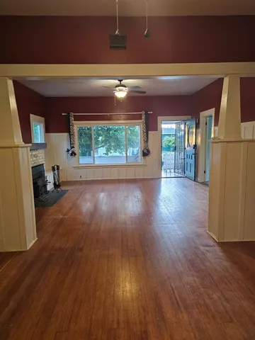 a view of a room with wooden floor and a window