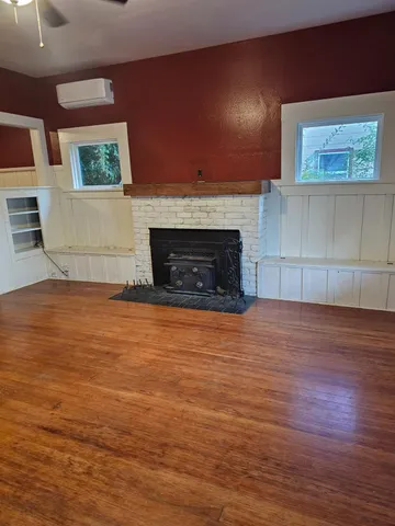 a view of empty room with wooden floor and fireplace